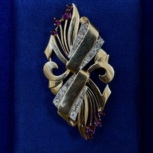 BROCHE ART DECO MONTADO EN ORO AMARILLO DE LEY 18KTS. CON BRILLANTES  0,90CTS Y PIEDRAS ROJAS.