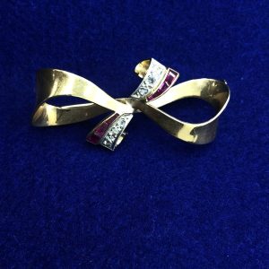 Broche en forma lazo con brillantes  montado en oro amarillo de ley 18kts