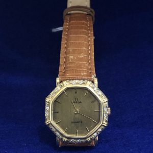 Reloj Omega vintage de señora, forma octogonal con brillantes y caja en oro de ley 18 kts. Mecanismo de cuarzo, pulsera de piel marrón.